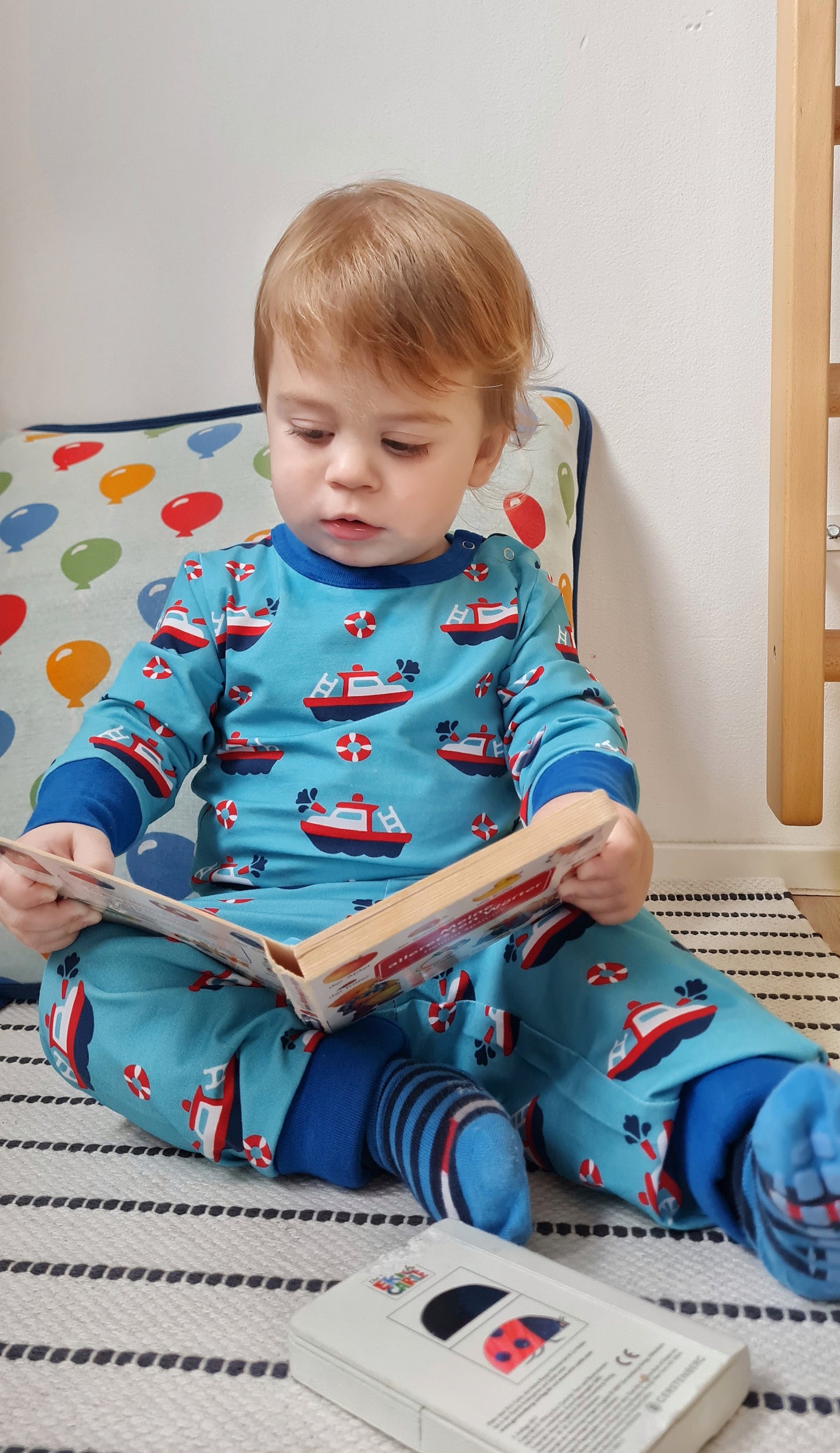 Mėlynas, laiveliais margintas vaikiškas smėlinukas ilgomis rankovėmis iš GOTS sertifikuotos organinės medvilnės.