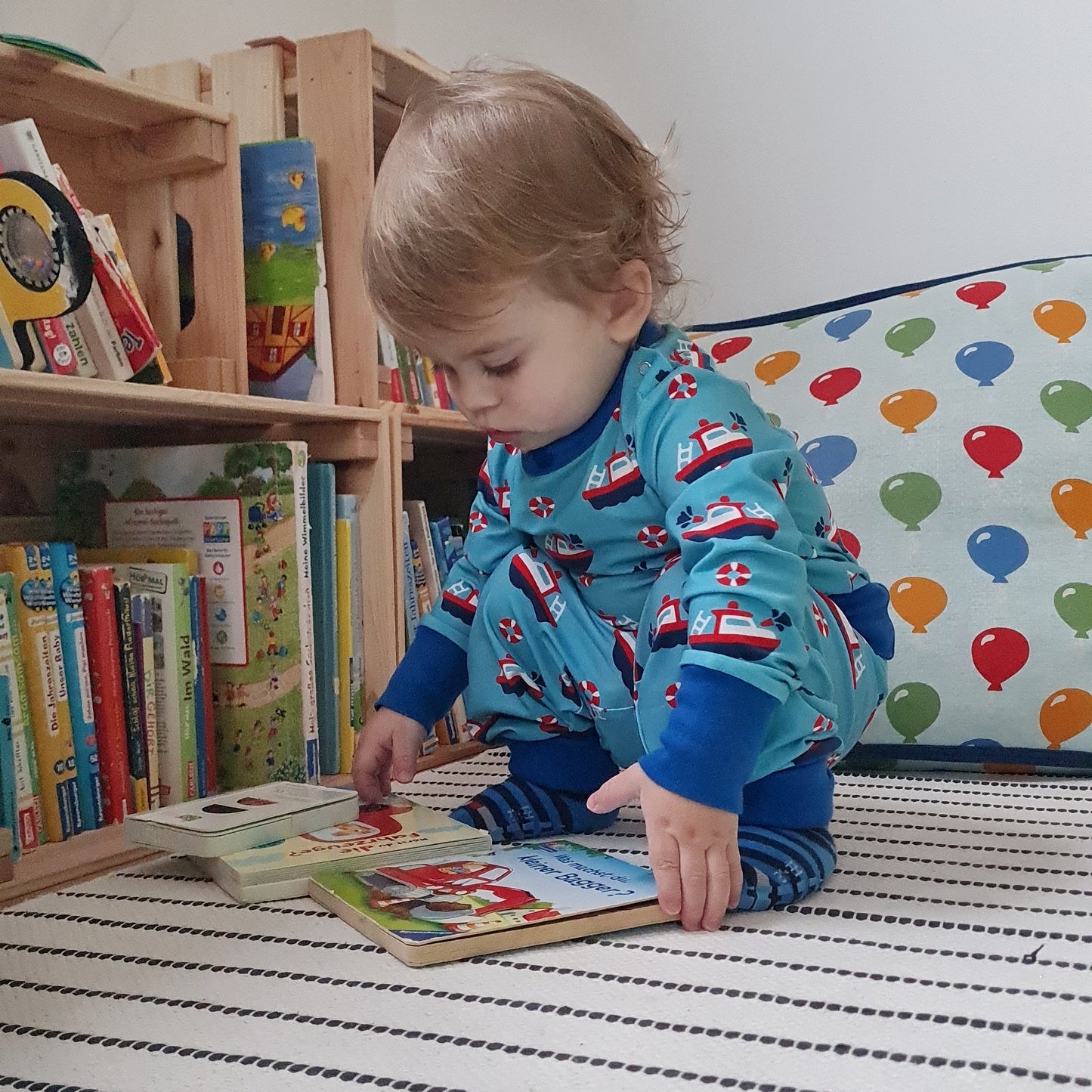 Mėlynas, laiveliais margintas vaikiškas smėlinukas ilgomis rankovėmis iš GOTS sertifikuotos organinės medvilnės.